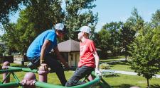 This image shows two boys on the playground during the youth adaptive summer camp.