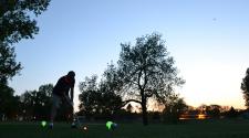 This image shows a male getting ready to tee off at Glow Golf.