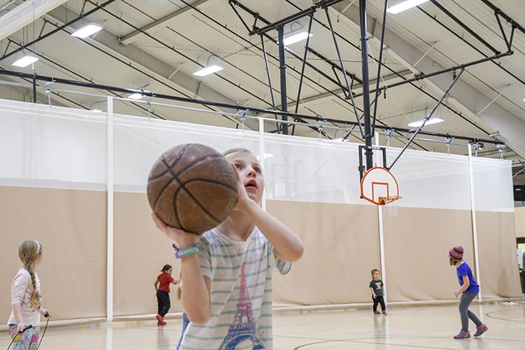 This image shows a girl shooting a basketball at the youth basketball program.