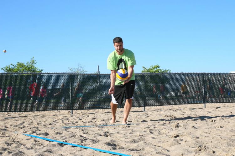 This image shows a male volleyball player serving.