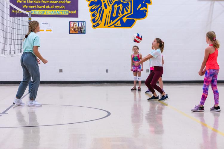 Youth Volleyball.jpg This image shows four girls playing volleyball.