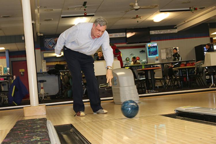 This image shows a male bowling with the adaptive bowling program.