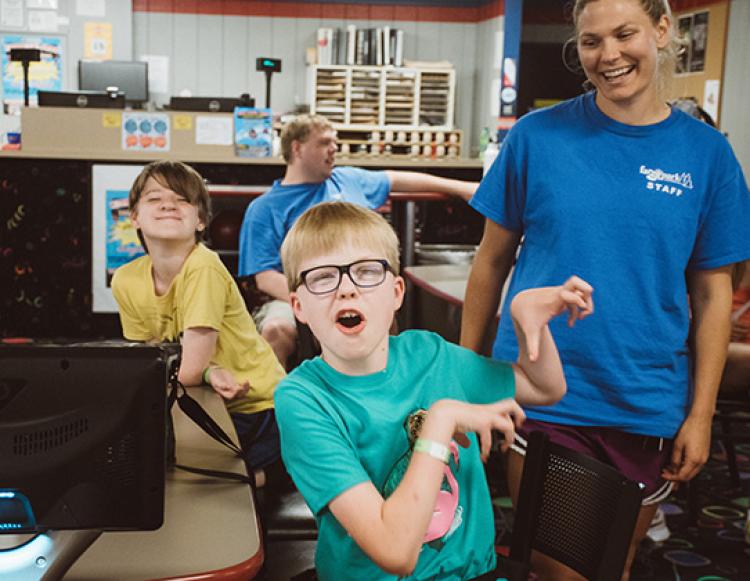 adaptivesummercamp This image shows two boys and an instructor posing for the camera during the youth adaptive summer camp.