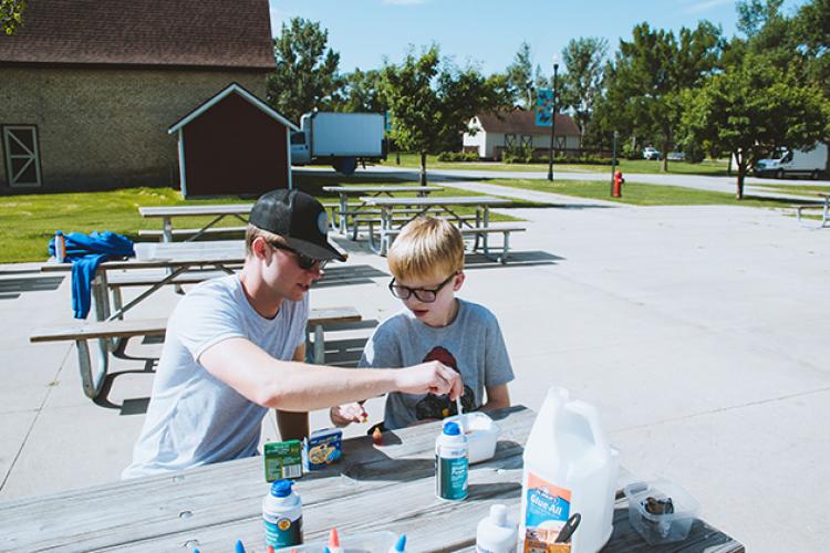 adaptivesummercamp2 This image shows a boy and instructor making a craft during the youth adaptive summer camp.