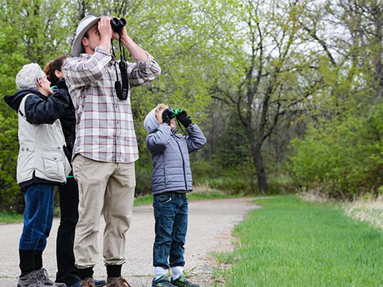 This image shows a young boy and the instructor looking into the sky during the birding program.