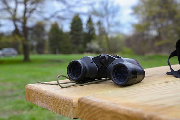 This image shows a pair of binoculars on a table for the birding program.