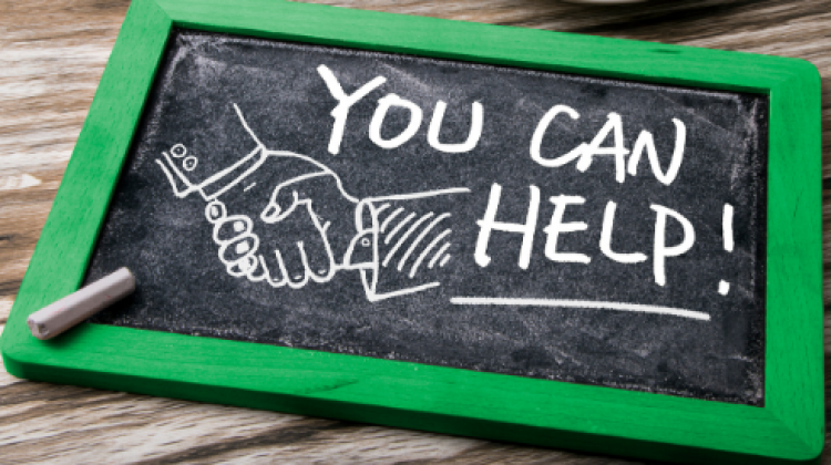 broadwaysquareshelp_stockphoto This image shows a you can help sign on a table.