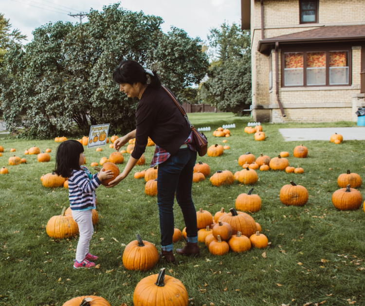 This image shows a mom and daughter picking out a pumpkin at Fall in Fargo.
