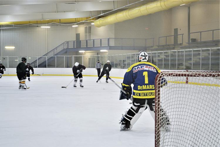 This image shows the goalie getting ready to make a save at adult hockey.
