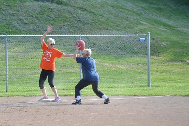 kickballleague4 This image shows a female trying to get another player out at a base during kickball league.
