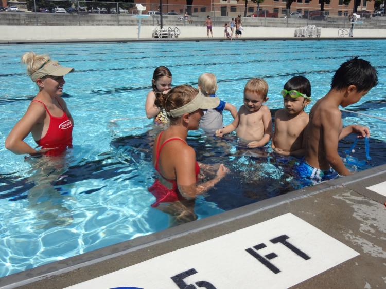 lifeguard_5.jpg This image shows two femaile lifeguards teaching kids to swim.