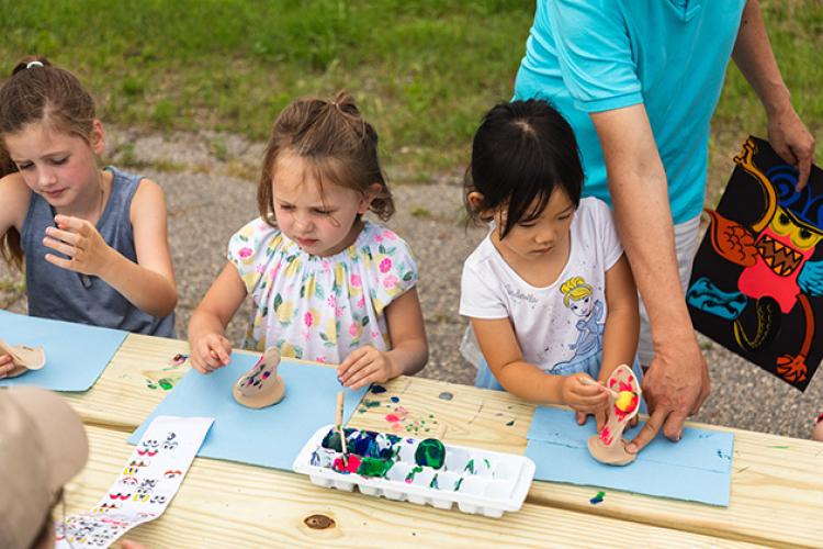 This image shows three girls working on their monsters at a craft table during Monstrous Imagination.