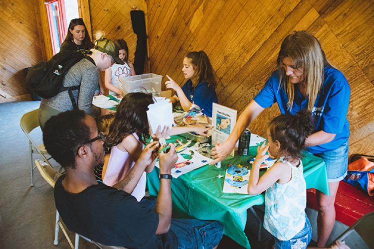 This image shows a table indoors of kids learning how to make a project from the instructors at Park It.