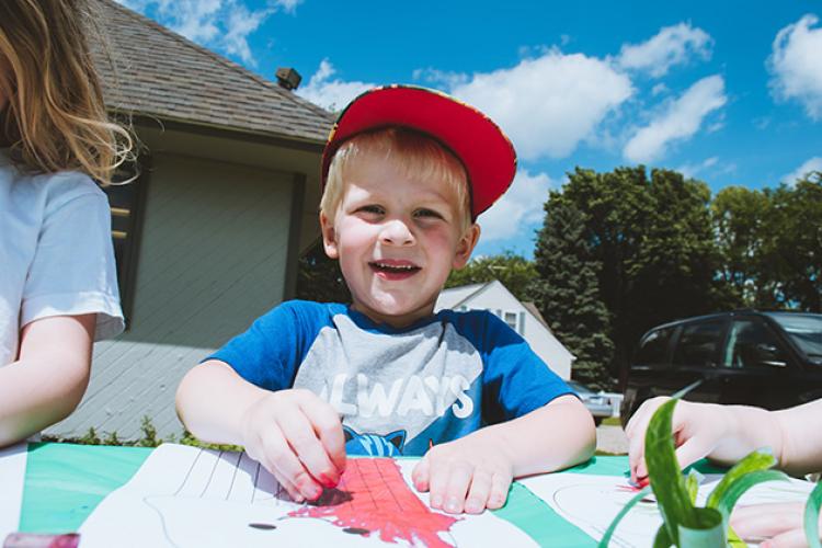 This image shows a young boy coloring outdoors during Park It.