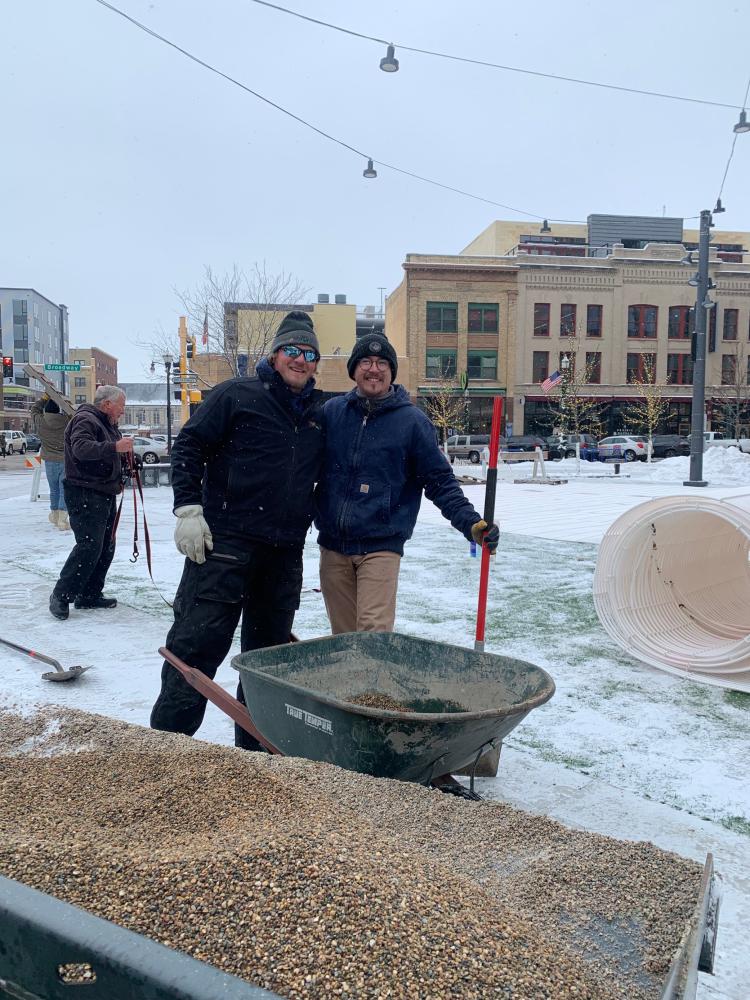 two men with shovel and wheelbarrow.