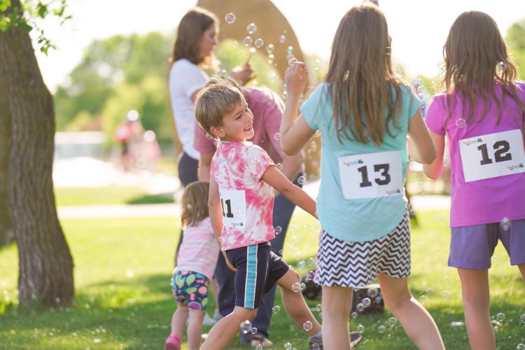 Kids playing in with bubbles while waiting for next event in Kids Triathlon