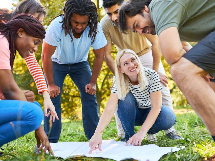 Group 6 people, 3 women-3men, looking down on a map