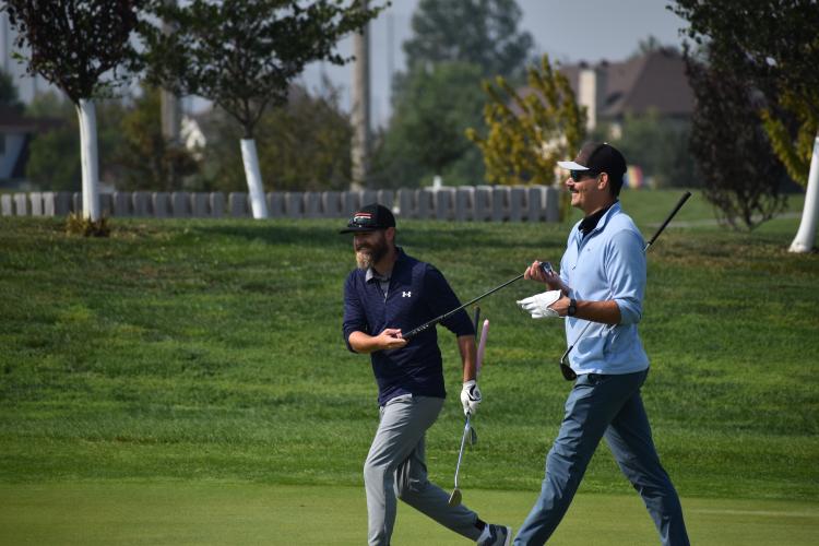 two men walking on a golf course