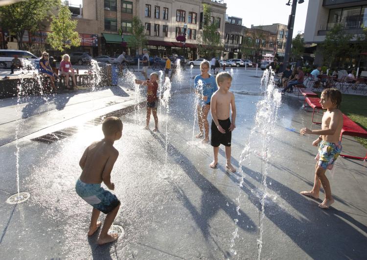 Young children playing at the interactive water fountains