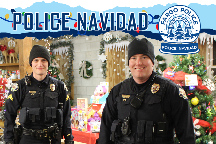 Police Navidad at Santa Village.png Two Policemen standing in the Santa Village barn with loads of donated gifts and food. POLICE NAVIDAD above the men and the Fargo Police snow globe