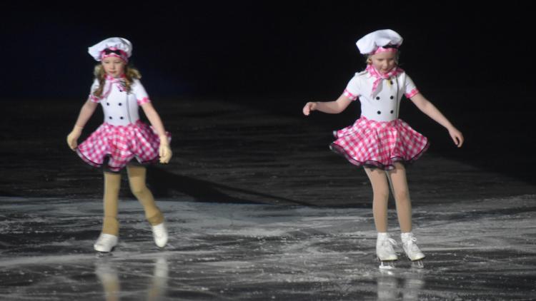 Ice Revue two girls in pink and white chef outfits ice skating to a routine for the Fargo Parks Ice Revue
