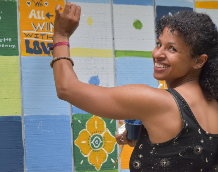 Photo of woman painting community mural