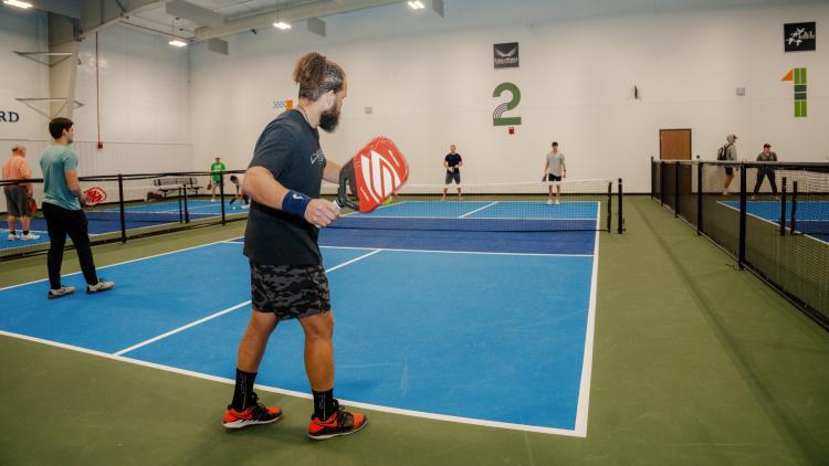 4 men playing pickleball on the Fargo Parks Sports Center pickleball courts