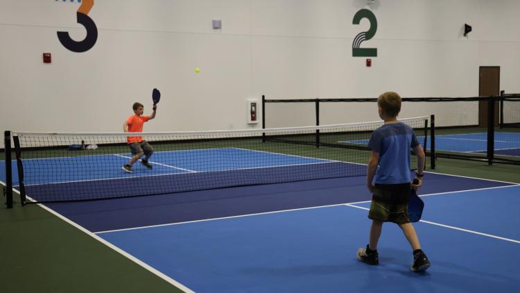 two boys playing pickelball on the Fargo Parks Sports Center pickleball courts