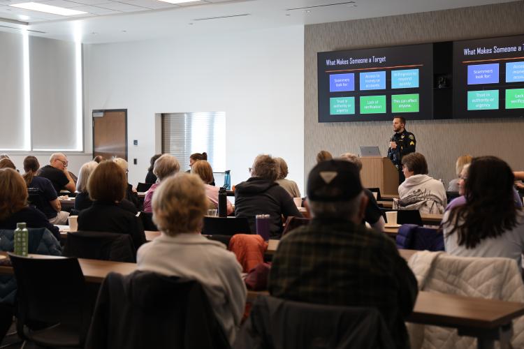 Police gives a talk to a conference room full of adults.