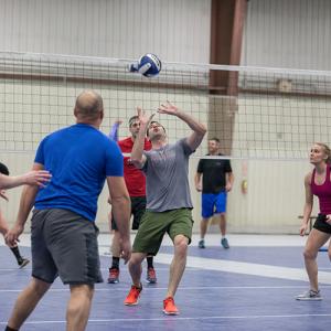 This image shows a male volleyball player setting up a serve. 