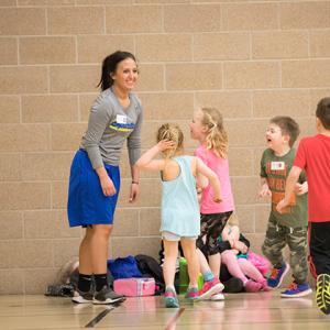 This image shows a group of kids running to the instructor at the sports sampler.