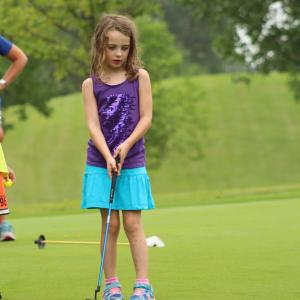 This image shows a girl golfing at El Zagal Public Golf Course. 