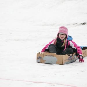 little girl cardboard sledding
