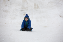 This image shows a boy sledding.