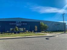 This photo shows the front of Cornerstone Bank Arena - a blue building with the Cornerstone Bank Logo