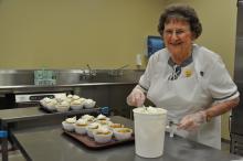 This image shows a woman serving dessert for valley senior services