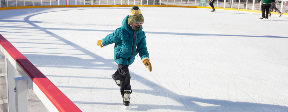 This image shows a young boy skating on the rink at Broadway Square.