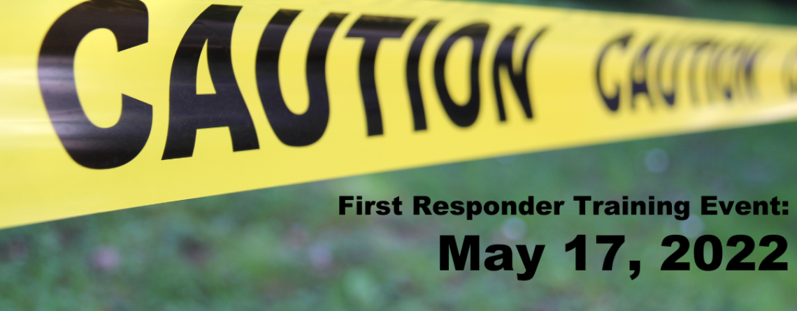 Photo shows caution tape running across grass area with text reading "First Responder Training Event: May 17, 2022"