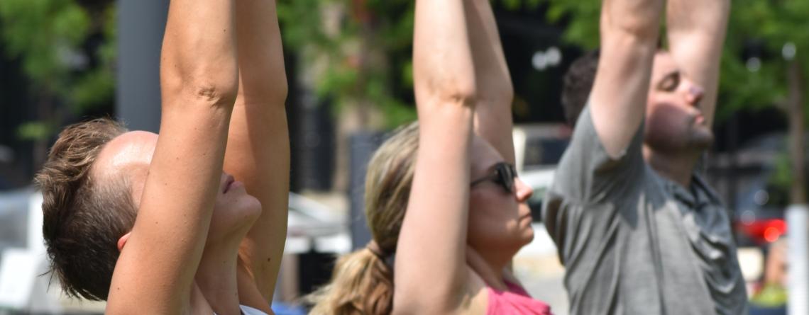 People doing yoga at Broadway Square