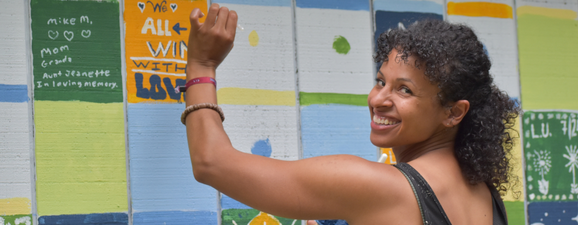 Photo of woman painting community mural