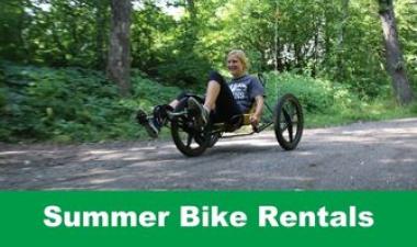 This image shows a graphic of "Summer Bike Rentals" with an image of a woman smiling as she bikes along a path.