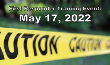 Photo shows caution tape running across grass area with text reading "First Responder Training Event: May 17, 2022"