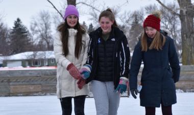 three girls skating on outdoor skating rink