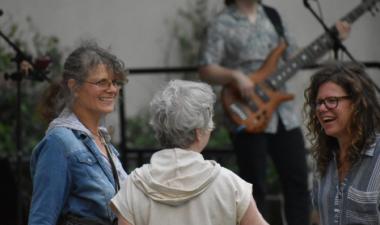 Photo of three women dancing to live band at broadway square