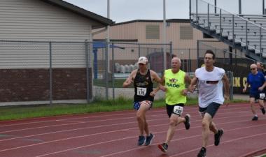 Photo of three senior athletes racing on a track. 