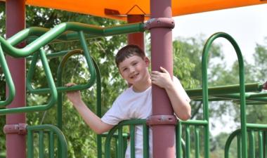 Photo of child playing on green and yellow playground