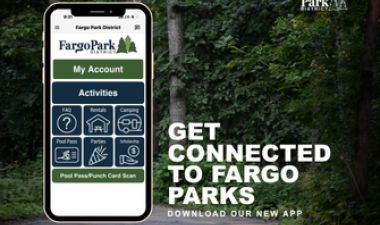 Promotional graphic for the new Fargo Park District app featuring a smartphone displaying app options over a wooded park trail. Text reads, “Get connected to Fargo Parks. Download our new app.”