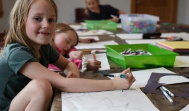 Children draw and create art together during a hands-on community education activity.