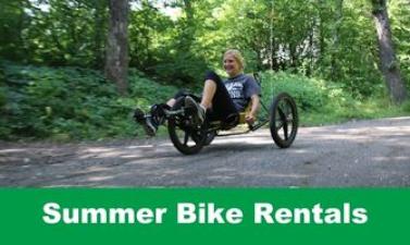 This image shows a graphic of "Summer Bike Rentals" with an image of a woman smiling as she bikes along a path.