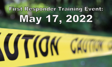 Photo shows caution tape running across grass area with text reading "First Responder Training Event: May 17, 2022"